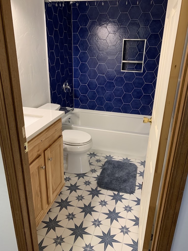 Custom tile work with hexagon shower tile and decorative floor pattern