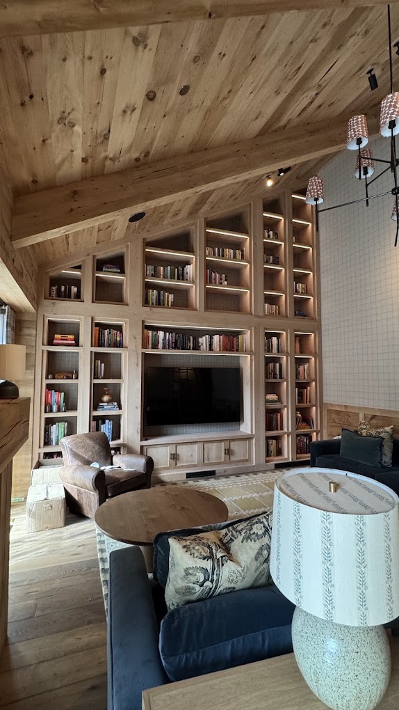 Luxury living room with custom built-in bookshelves, vaulted wood ceiling, and warm lighting — built by Bulldog Construction.
