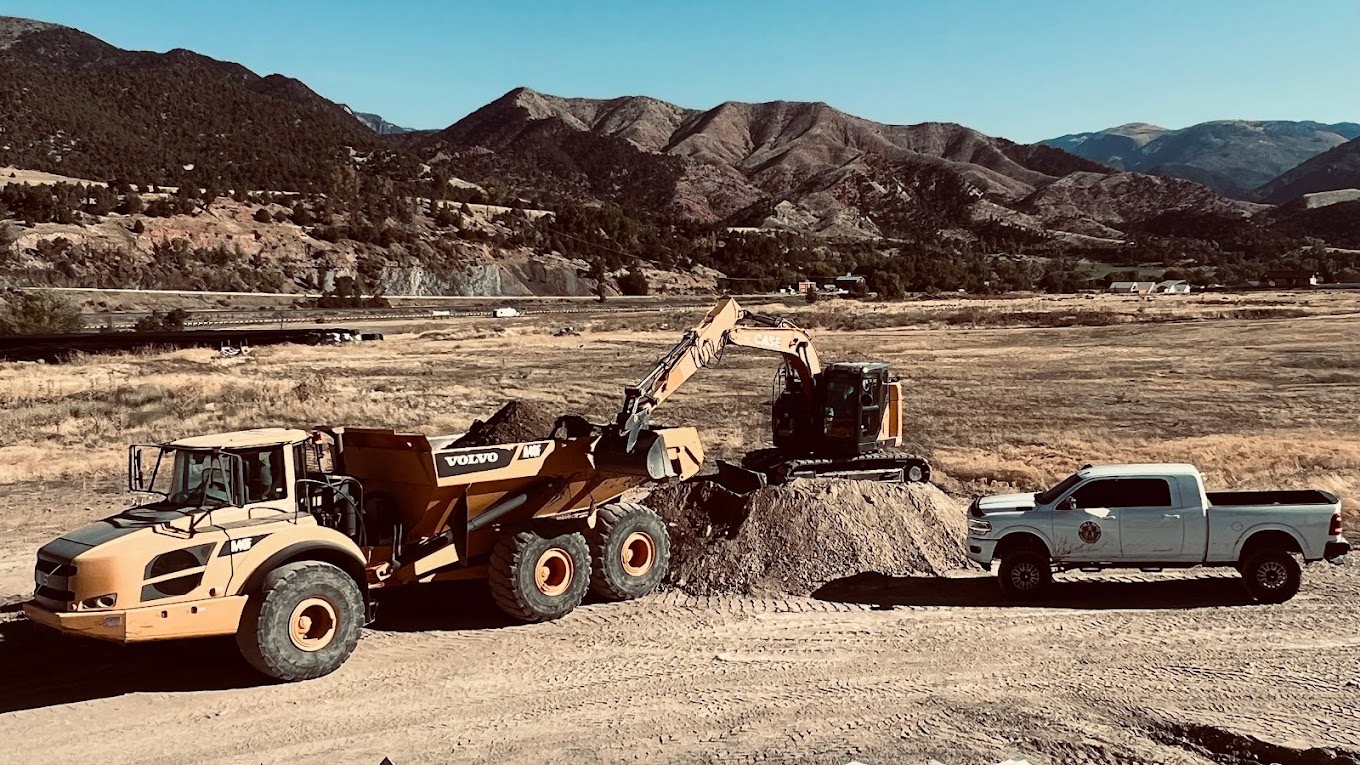 Excavation site preparation with heavy equipment in a Colorado mountain valley